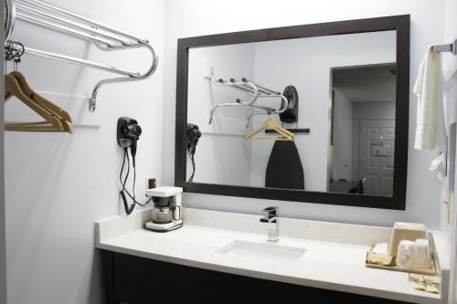 a bathroom with a sink and a large mirror at Kings Inn in Rome
