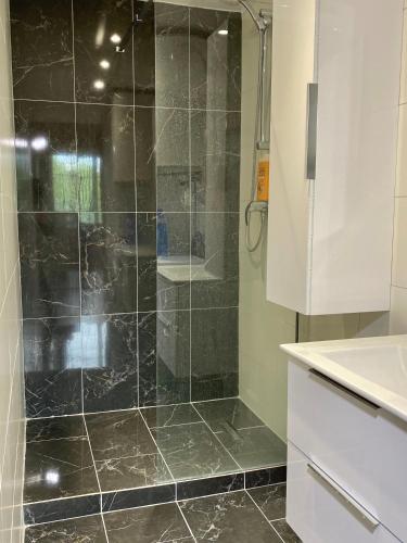 une douche avec une porte vitrée dans une salle de bain dans l'établissement Le Rockefeller, à Lyon