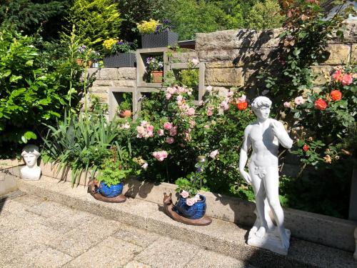 a statue of a girl in a garden with flowers at Sonnenhaus in Sindelfingen