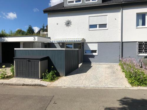 a white house with a gate and a driveway at Sonnenhaus in Sindelfingen