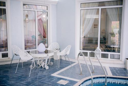 a dining room with a table and chairs and a pool at Fruška Gora Klub Krstašice in Irig