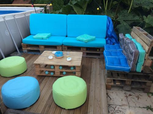 a blue couch sitting on a deck with a coffee table at Le Château du Bonheur, Piscine, Sauna et Jacuzzi in Le Loreur