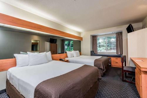 A bed or beds in a room at Microtel Inn & Suites by Wyndham Bethel/Danbury