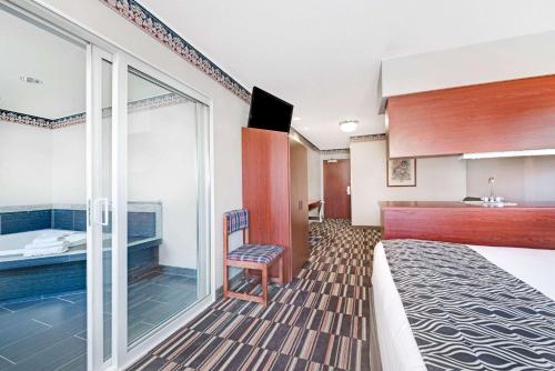 a hotel room with a bed and a kitchen at Microtel Inn & Suites Urbandale in Urbandale
