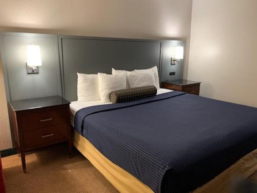 a bedroom with a large bed and two night stands at Days Inn by Wyndham Great Lakes Naval Base in North Chicago