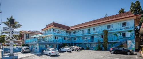 un edificio azul con coches estacionados en un estacionamiento en Aqua Breeze Inn, en Santa Cruz