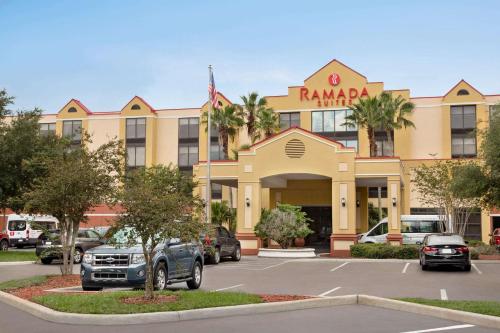 um parque de estacionamento em frente a um hotel em Ramada by Wyndham Suites Orlando Airport em Orlando