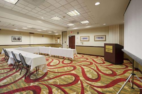 a conference room with tables and chairs on a carpet at Ramada by Wyndham Suites Orlando Airport- Free Airport Shuttle in Orlando