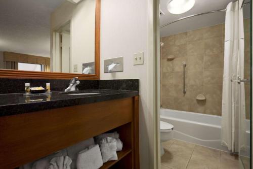 y baño con lavabo, aseo y espejo. en Days Inn by Wyndham Las Cruces, en Las Cruces