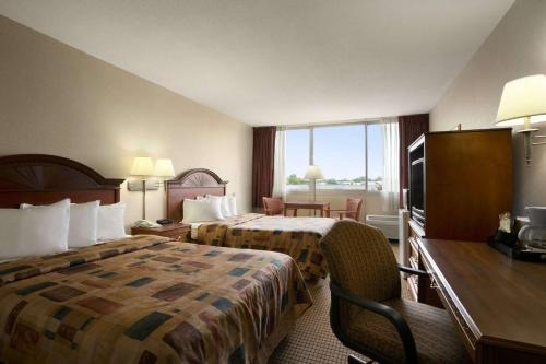 a hotel room with two beds and a desk at Days Inn by Wyndham Sidney OH in Sidney