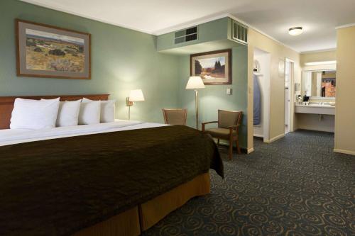 Llit o llits en una habitació de Days Inn & Suites by Wyndham Trinidad