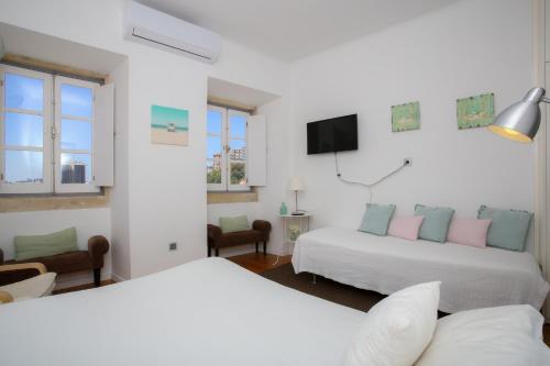 a hotel room with two beds and a tv at Apartamentos com Historia in Coimbra