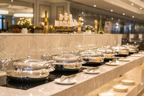 a buffet line with glasses and plates and a ship at Mercure Hotel Changchun Hengxing in Changchun
