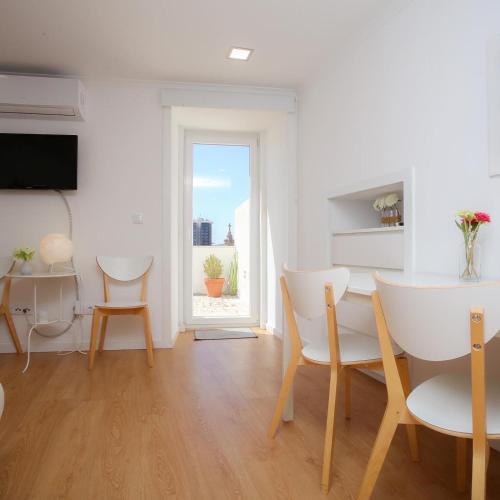 a living room with a table and chairs and a window at Apartamentos com Historia in Coimbra