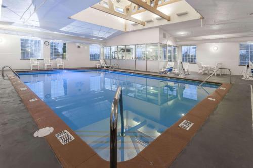 a large swimming pool with blue water in a building at Days Inn by Wyndham Pentwater in Pentwater