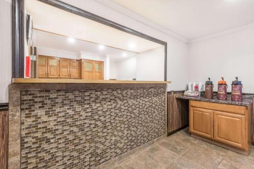 uma cozinha com um espelho e uma parede de tijolos em Super 8 by Wyndham Bedford em Bedford