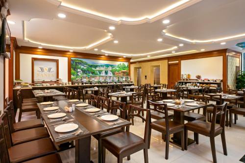 a restaurant with tables and chairs in a room at Santa Luxury Hotel in Da Nang
