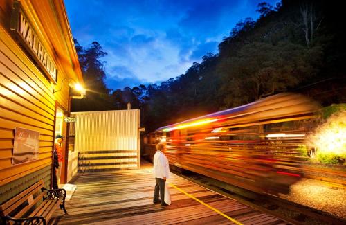 a man standing on a platform next to a train at Walhalla's Star Hotel in Walhalla