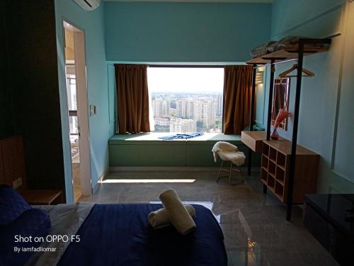 een slaapkamer met een bed en een groot raam bij Imperio Residence City View in Melaka