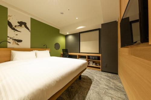a bedroom with a bed and a projection screen at The OneFive Kyoto Shijo in Kyoto