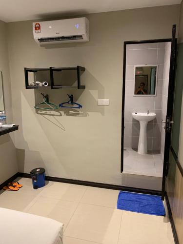 uma casa de banho com um WC, um lavatório e um espelho. em Memory Boutique Hotel em Semporna