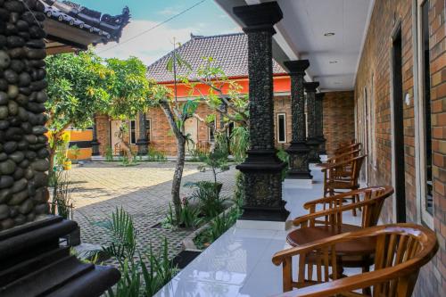 a patio with wooden chairs and a courtyard at Hotel Niki in Jembrana