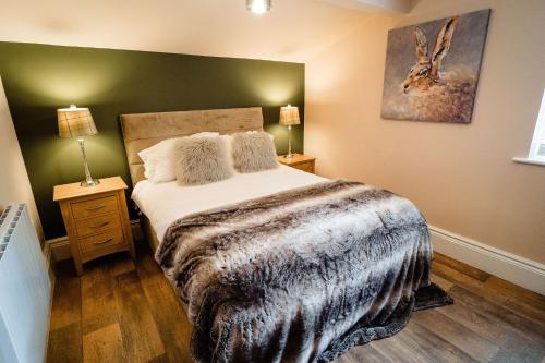 a bedroom with a bed with a blanket on it at The Rectory Rooms, Studio 4 in Skipton