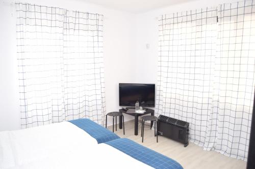 1 dormitorio con cama, mesa y TV en Hotel Road Rooms en Voluntari