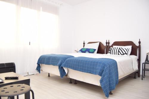 a bedroom with a bed with a blue plaid blanket at Hotel Road Rooms in Voluntari