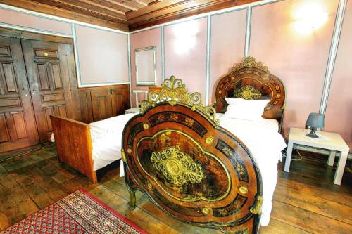 a bedroom with a bed with a wooden headboard at Guest House Old Plovdiv in Plovdiv