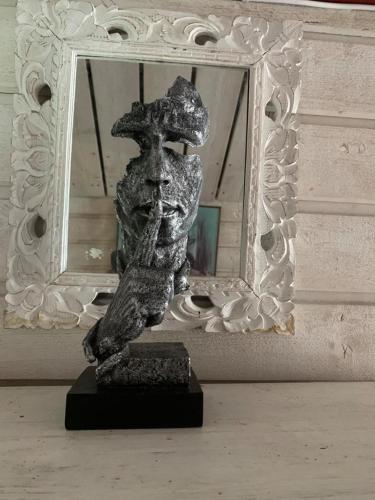 a statue of a man in front of a mirror at Stugan med Bryggan i Gamla Staden in Eskilstuna