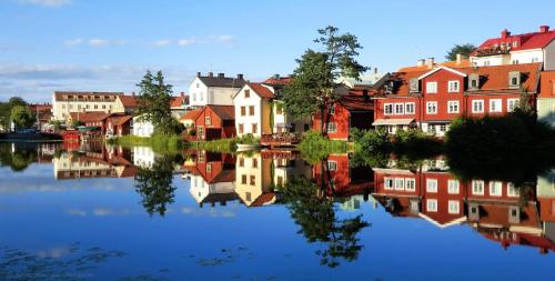 Stugan med Bryggan i Gamla Staden في إسكيلستونا: مجموعة منازل بجانب تجمع مياه