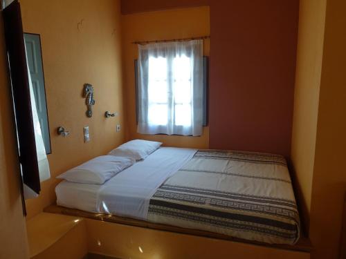 a bedroom with two beds and a window at Merovigla Studios in Imerovigli