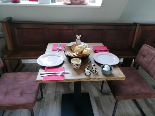 Chez Bob في Bovenkarspel: طاولة وصحنين وسلة خبز