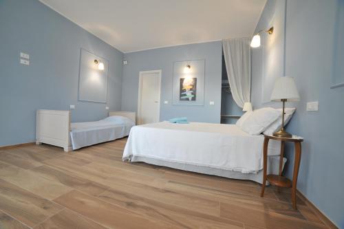a bedroom with blue walls and a bed and a lamp at B&B L'OFFICINA DEI SOGNI in Poggio Morello
