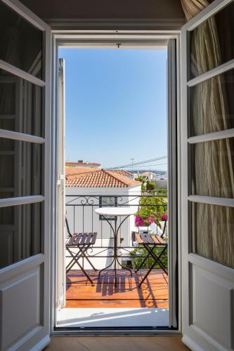 an open door to a balcony with a table and chairs at Guesthouse Niriides in Spetses
