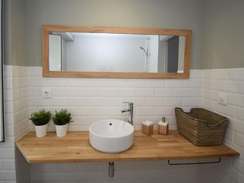 a bathroom with a white sink and a mirror at Hotel A Falúa in Puentedeume