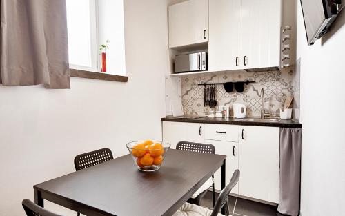 una cucina con tavolo e ciotola di arance di Sabbinirica, casa vacanze a Ragusa