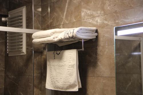 a bathroom with a rack with towels and a mirror at Alâ Avsa Hotel in Avşa Adası