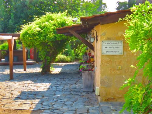 a small yellow building with a sign on it at THE MANSION in yesod hamaala in Yesod Hamaala