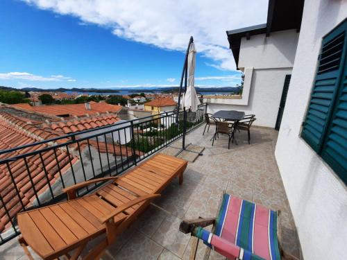 a balcony with a table and chairs and an umbrella at Apartment Baratula in Murter