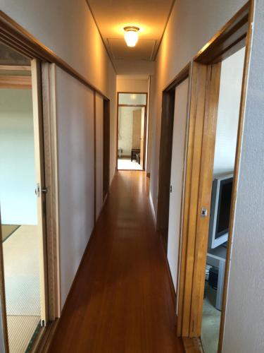 a hallway of an apartment with wooden floors and doors at 浜の宮七福神 1棟貸し9名様までご利用できます in Nachikatsuura