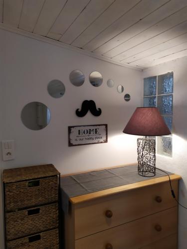 a room with a table with a lamp on a dresser at La maison D'Orée in Polignac