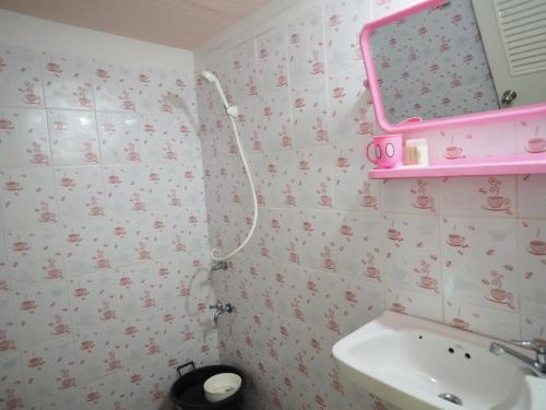 y baño con lavabo y espejo de color rosa. en Pattama Resort @ KeereWong, en Kiriwong