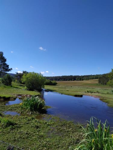 a river in the middle of a field at La maison D'Orée in Polignac