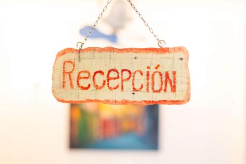 a sign with the word reception hanging from a chain at Kelebek Butik Pansiyon in Ayvalık