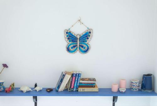 une étagère bleue avec un papillon sur le mur dans l'établissement Kelebek Butik Pansiyon, à Ayvalık