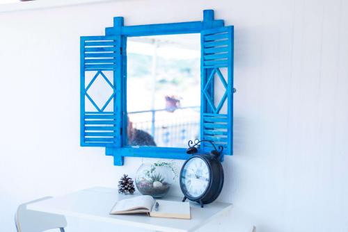 a mirror and a clock sitting on a table at Kelebek Butik Pansiyon in Ayvalık
