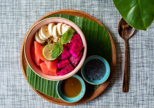 eine Schale Obst auf einem Teller auf einem Tisch in der Unterkunft PinkPrivate Sanur - for Cool Adults Only in Sanur