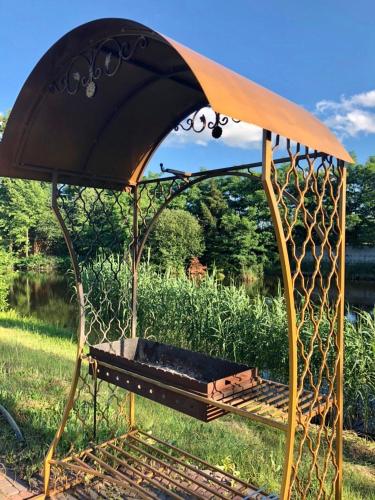 a barbecue grill in the grass next to a field at Фінський будинок для ідеального романтичного чи сімейного відпочинку in Makovishche